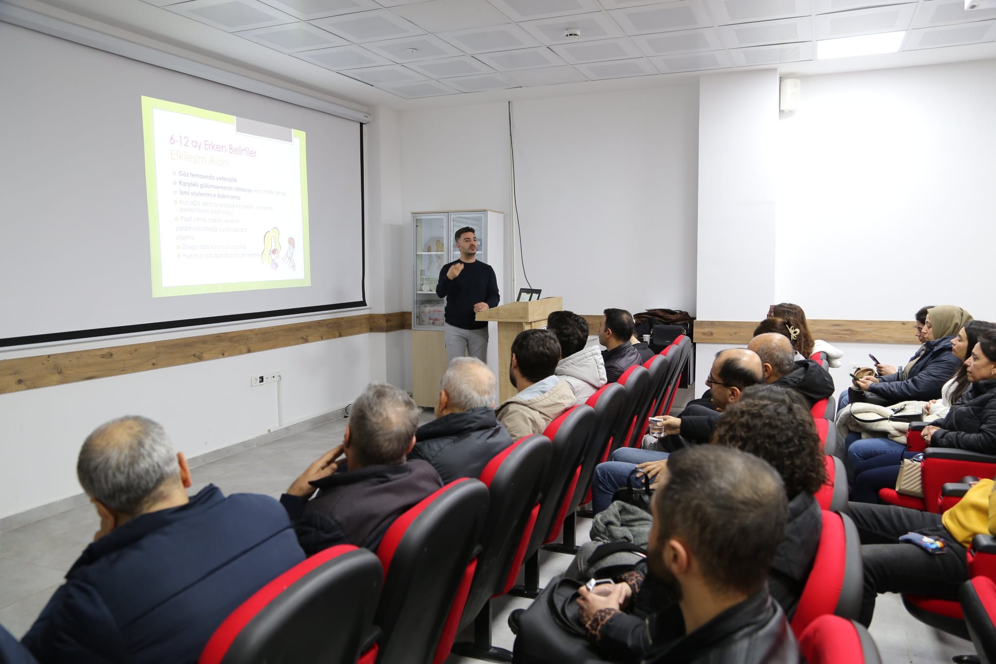 Uzm. Dr. Hüseyin Tunca erken gelişim basamakları ve otizm belirtileri sunumu yaparken