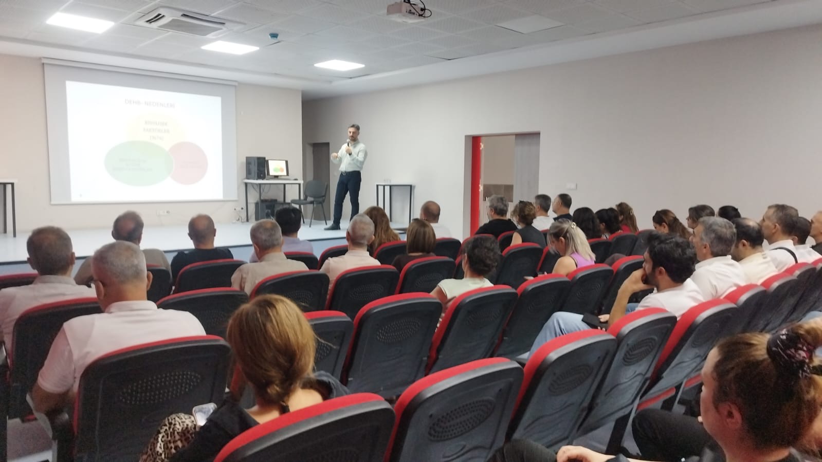 Uzm. Dr. Hüseyin Tunca amfide DEHB Nedenleri ve Nörobiyolojik Süreçler sunumu yaparken